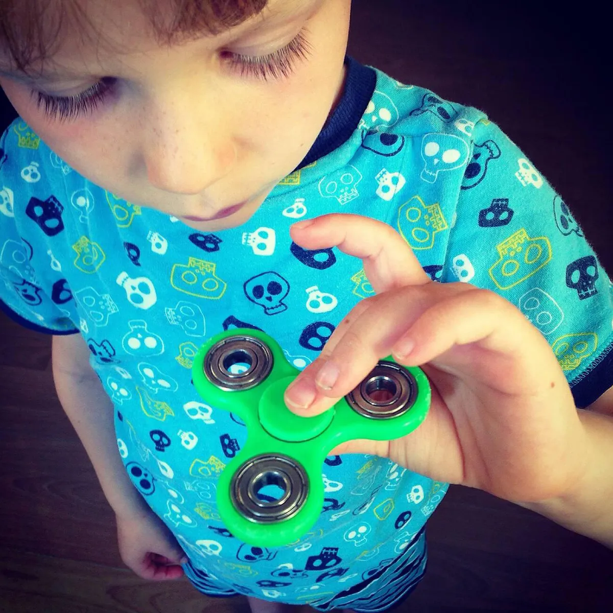 boy with ADHD playing with a fidget spinner, illustrating a coping mechanism for managing restlessness and improving focus boy with ADHD playing with a fidget spinner, illustrating a coping mechanism for managing restlessness and improving focus